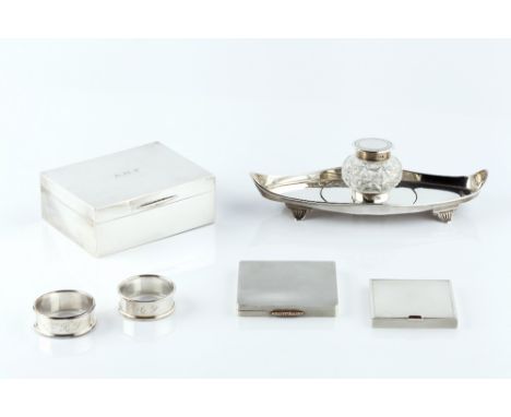 AN EDWARDIAN SILVER INKSTAND, of navette form, with single cut glass inkwell, 21cm long, London 1903; a silver engine turned 