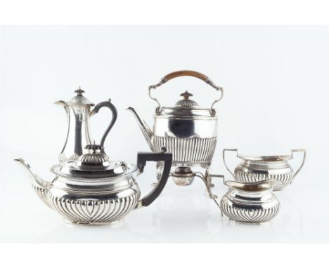 A MATCHED SILVER FIVE PIECE TEA SERVICE, of half lobed form, with ebonised handles, comprising teapot, milk jug and sucrier b