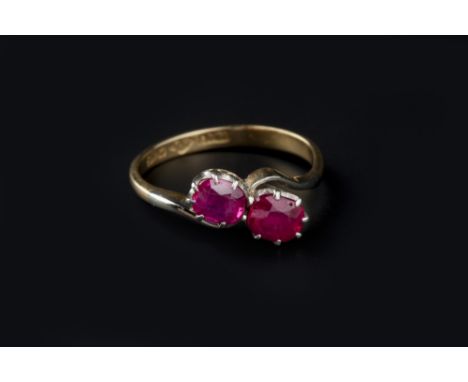 A RUBY TWO STONE RING, of crossover design, the cushion-shaped mixed-cut rubies in claw setting, to shank stamped '18ct plat'