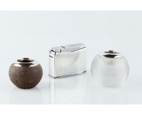 A GEORG JENSEN WHITE METAL TABLE LIGHTER, of Art Deco design, 8cm wide; and two silver mounted match strikers, one of ridged 