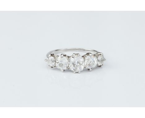 A DIAMOND FIVE STONE RING, the graduated cushion-shaped old-cut diamonds in claw setting, white precious metal mounted, total