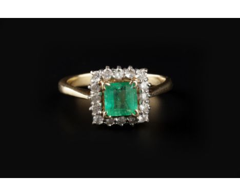 AN EMERALD AND DIAMOND CLUSTER RING, the rectangular step-cut emerald claw set within a border of round brilliant-cut diamond