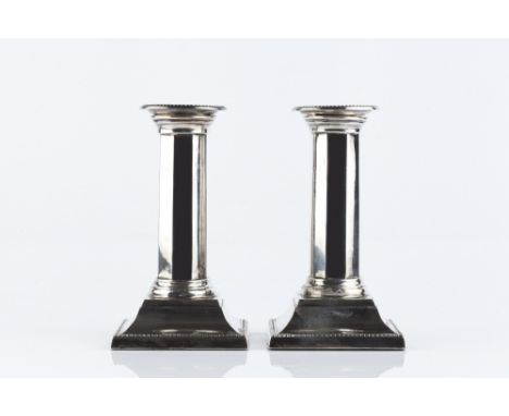 A PAIR OF EDWARDIAN SILVER CANDLESTICKS with beaded borders and stepped square bases by Martin, Hall & Co., Sheffield 1904, 1