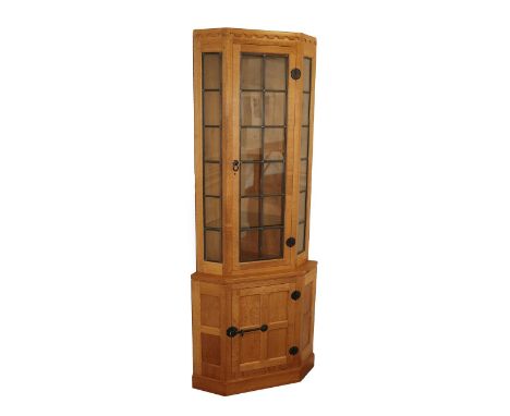 Workshop of Robert Mouseman Thompson (Kilburn): An English Oak Corner Display Cupboard, post 1960's, the upper section with l