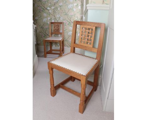 Workshop of Robert Mouseman Thompson (Kilburn): A Pair of English Oak Lattice Back Dining Chairs, white cow hide seats, on tw