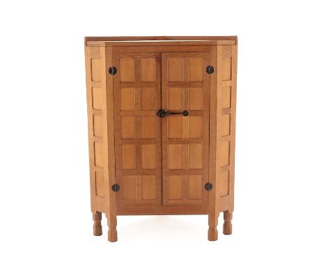 Workshop of Robert Mouseman Thompson (Kilburn): A Panelled English Oak Floor Standing Corner Cupboard, with raised upstand, a