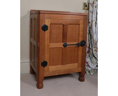 Workshop of Robert Mouseman Thompson (Kilburn): An English Oak Panelled Bedside Cupboard, with raised upstand, above a single