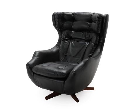 A Parker Knoll Statesman Egg Chair, with swivel and tilt mechanism, black vinyl upholstery with button back cushions, on a te