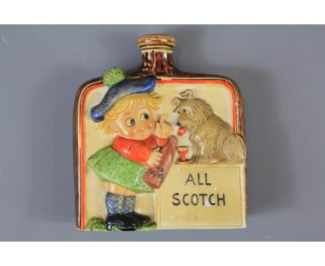 Vintage Pottery Flask. The flask depicting a young Scot showing his dog it's 'All Scotch', the flask has a stopper, approx 9 