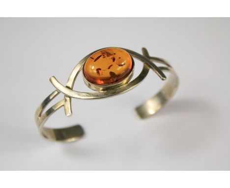 A Ladies Silver and Amber Bangle. The center amber approx 20 x 12 gms, approx 40 gms.