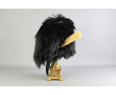 A Vintage British Foot Guard Bearskin. The cap made from fur of the Canadian Black Bear, with a cream plume with wicker cage 