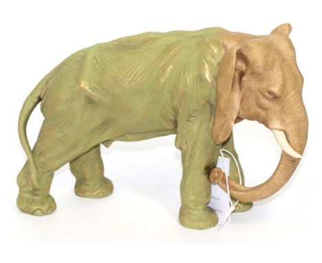 A Royal Dux style porcelain figure of an elephant, early 20th century, standing four square with buff head and trunk and gree