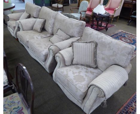 A modern three piece suite comprising a two seater sofa and two chairs together with a matching pouffe  