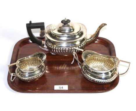 A composite silver three piece bachelor's teaset, the teapot by Natham & Hayes, Chester, 1908, the sucrier and milk jug by J 