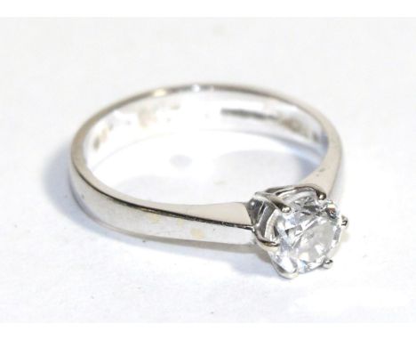 An 18 carat white gold diamond solitaire ring, a round brilliant cut diamond in a claw setting, to knife edge shoulders on a 