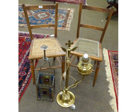 A pair of cane seated chairs, a coloured glass and brass lantern and a brass lamp 