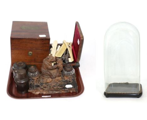 A group including a black forest inkwell carved with bears, a glass dome, travelling apothecary case, two treen canisters, pr