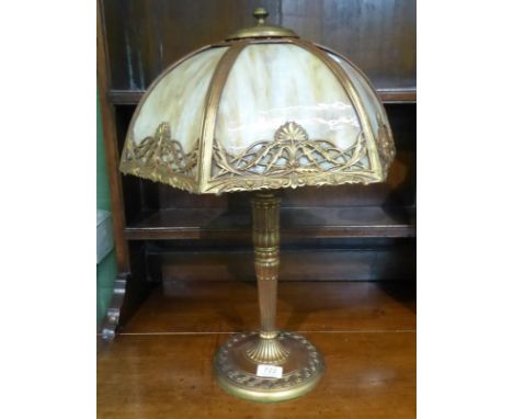 An early 20th century American gilt metal table lamp, with a domed mottled coloured glass sectional shade, on a circular cast