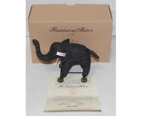 A Steiff "Felt Elephant On Wheels", limited edition, no.1916, having a gold plated button and white label, raised on cast whe