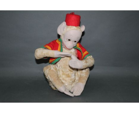 A 1930's Farnell musical monkey, measuring 32cm tall, in restored condition, and with its original working musical movement.