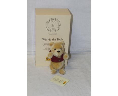 A Steiff 75th Anniversary "Winnie The Pooh" teddy bear, having a blonde mohair plush body, wearing the trademark red waistcoa