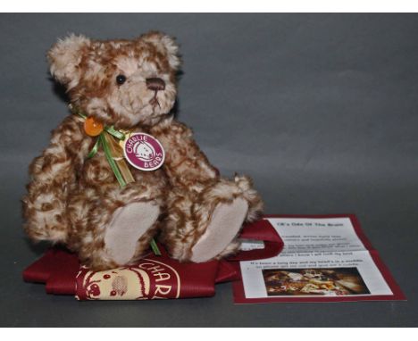 A soft plush "Button" Charlie Bear, CB194513, having a light brown and beige ruffled fur body, wearing a green and gold colou