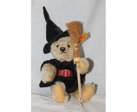 A Steiff 2003 "Hexe" witch teddy bear, wearing a witches hat, a cape, holding a broom, and measuring 24cm tall.