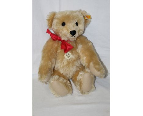 A Steiff Classic 1909 replica teddy bear, having a blonde mohair covered body, wearing a red bow tie, with a working growler 