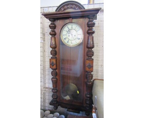 &nbsp;A walnut cased wall clock, with Roman numerals, the case with glazed door and turned half columns, height 41ins