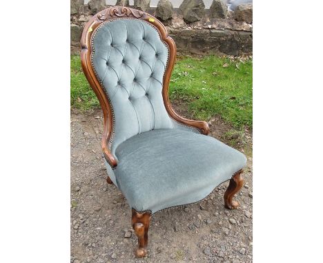 A Victorian show wood nursing chair, with carved and button spoon back, raised on short cabriole legs