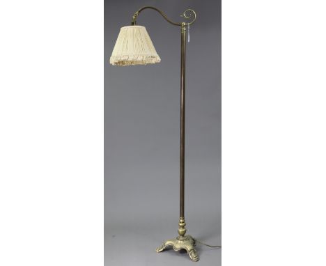 An Edwardian-style brass standard lamp, with scroll-arm &amp; on triform base, with shade.