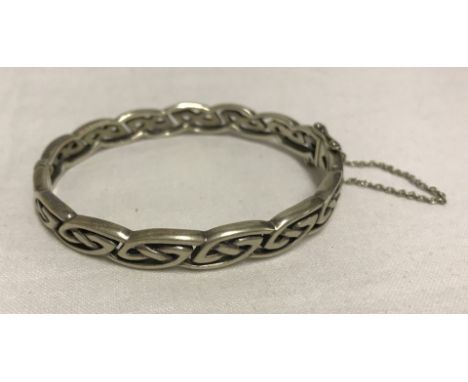 A 925 silver celtic design hinged bangle with safety chain.  