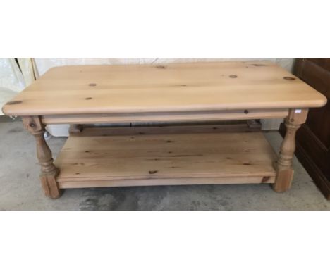 A modern pine rectangular coffee table with lower shelf and turned legs.  Approx. 120cm x 60cm x 48cm tall.