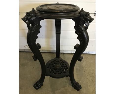 A vintage ebonised oriental wooden plant stand with carved dragon legs. Carved oriental pattern to base shelf. 81cm tall appr