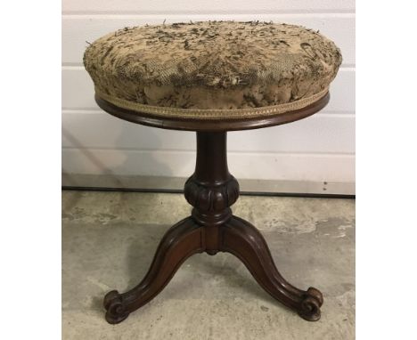 A Victorian mahogany pedestal based swivel top piano stool with tripod legs. Upholstery needs attention. 