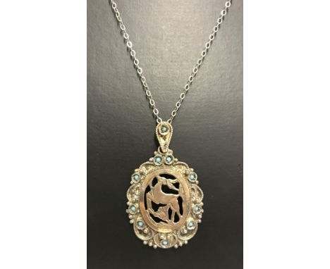A 925 silver pendant of a leaping deer set with small turquoise stones on a silver chain.  