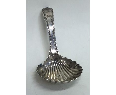 A small Georgian silver bright cut caddy spoon with fluted bowl. by JE. Approx. 9.6 grams. Est. £30 - £50.