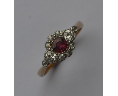 An attractive ruby and diamond daisy head cluster ring with large stones to shoulders and platinum mount. Approx. 3 grams. Es