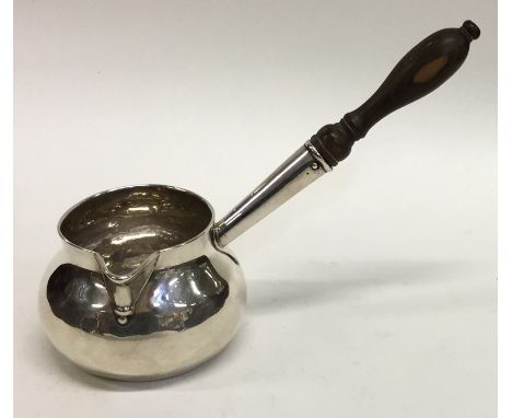 A good Georgian silver brandy pan with turned handle and pouring lip. London 1727. Approx. 90 grams. Est. £300 - £400.