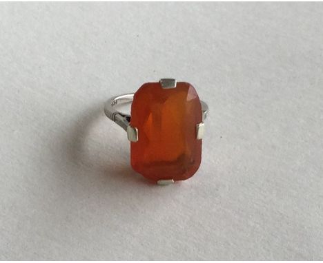 A large rectangular fire opal mounted as a ring in white gold claw mount. Approx. 3.7 grams. Est. £100 - £150.