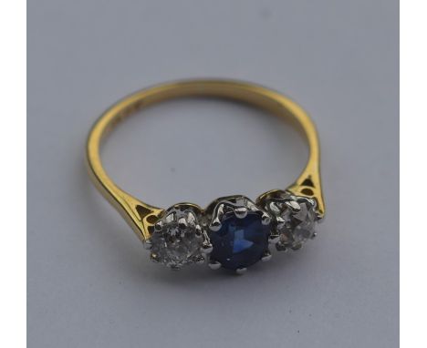 An 18 carat gold sapphire and diamond three stone ring in two colour claw mount. Approx. 2.8 grams. Est. £250 - £300.