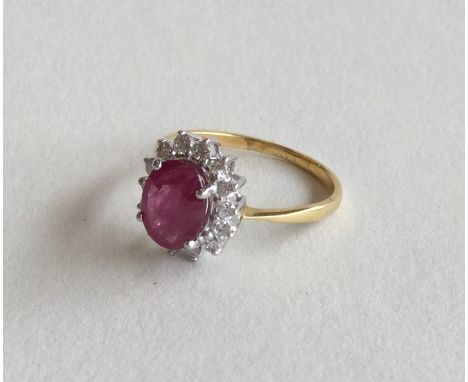 A ruby and diamond cluster ring in 18 carat claw mount. Approx. 2.8 grams. Est. £100 - £150.