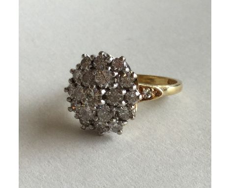 A large diamond cluster ring in 18 carat and platinum carved setting. Approx. 7 grams. Est. £300 - £400.