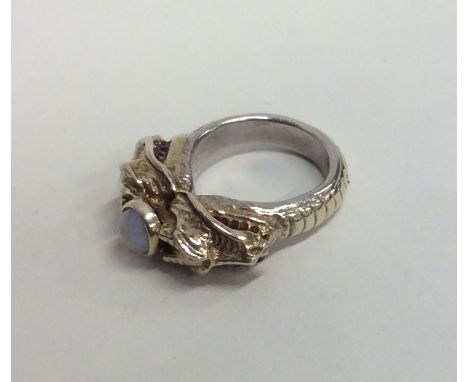A silver and silver gilt opal ring decorated with serpents. Approx. 21 grams. Est. £40 - £60.