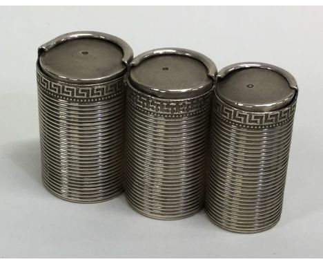 FABERGÉ : A silver three section graduated coin holder, of cylindrical ribbed form with Greek key border. Stamped with Faberg
