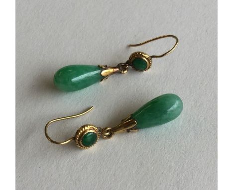 A pair of Chinese jade drop earrings with high carat gold loop tops. Approx. 4 grams. Est. £100 - £150.