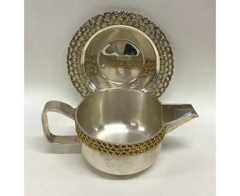 STUART DEVLIN: A stylish silver and silver gilt sauce boat on matched stand of typical design. Approx. 432 grams. Est. £500 -