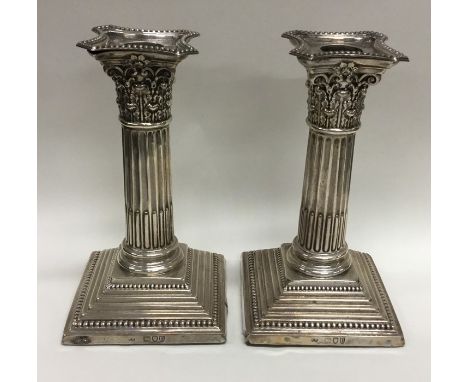 A pair of Corinthian column dwarf candlesticks on step bases. London. By CB. Approx. 883 grams. Est. £100 - £150.