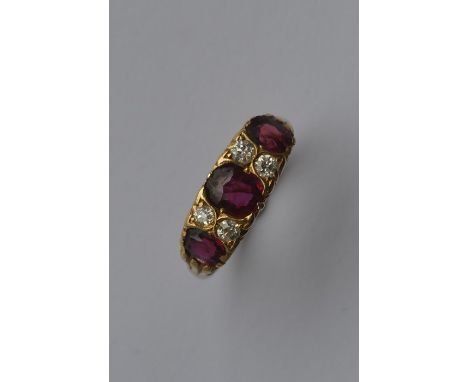 A good ruby and diamond seven stone half hoop ring. Approx. 4.3 grams. Est. £500 - £800.