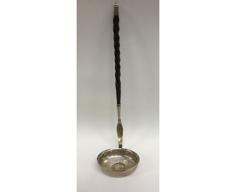 A large silver toddy ladle with whalebone handle inset with coin. Approx. 55 grams. Est. £30 - £50.
